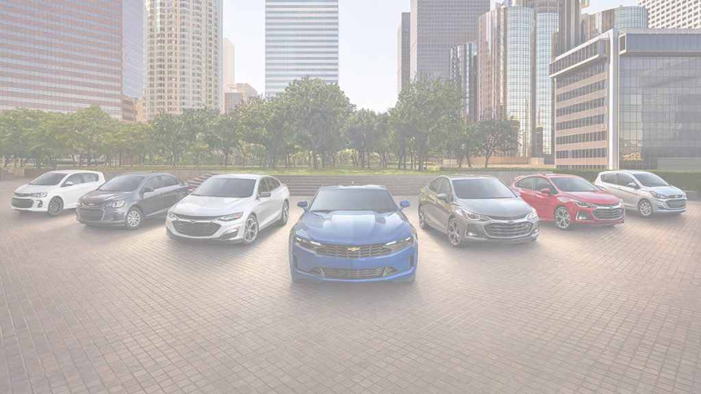 Lineup of 2019 Chevy models in front of a city park.